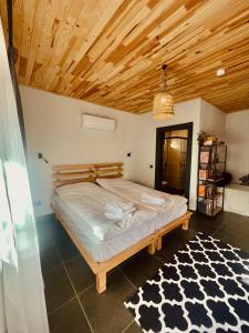 Schlafzimmer mit einem Bett mit Holzdecke in der Unterkunft Casa Natura Adrasan in Adrasan