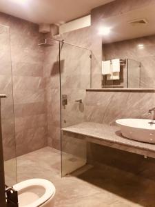 a bathroom with a shower and a sink and a toilet at Cozy Guest Room F-7 Markaz Islamabad in Islamabad