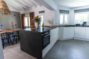 a kitchen with white cabinets and a black counter top at Casa Dona in Denia