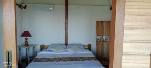 a bedroom with a bed with a wooden frame at Bali Jungle Cabin in Jatiluwih