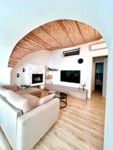 a living room with a couch and a tv at L’Arco sul Lago • Gold Apartment in Castro