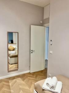 a white room with a mirror and a bed at Gioia di Roma in Rome