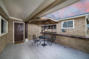 a patio with a table and chairs and an umbrella at Nite Inn at Universal City - Walking Distance to Universal Studios Hollywood in Los Angeles