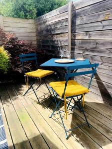 Una mesa azul y dos sillas en un patio. en Appartement entier en centre-ville avec terrasse, en La Rochelle