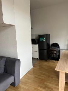 德累斯顿Ferienwohnung für kleine und große Reisegruppe的带沙发的客厅和带冰箱的厨房。 更多9张照片