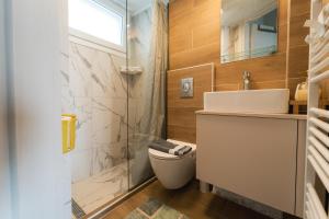 a bathroom with a toilet and a sink and a shower at Aegean Twin Houses in Iraklitsa +89 photos