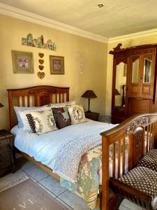 a bedroom with a wooden bed with pillows at Villa Afriq in Lydenburg