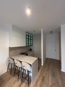 une cuisine avec des armoires blanches et une table et des chaises dans l'établissement Kesselbauer with parking, à Bratislava