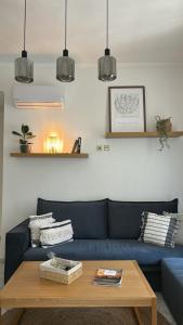 a living room with a blue couch and a table at Apeiron Acropolis Suites in Athens
