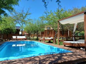 a swimming pool in a yard with a pavilion at Cabañas Lignum Tiny House in La Granja