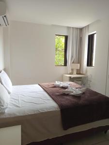 Un dormitorio blanco con una cama y una ventana. en Iloa 02 quartos, Barra de São Miguel, en Barra de São Miguel