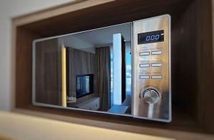 un four micro-ondes installé au-dessus d'une étagère dans l'établissement HolidayHomePL Bel Mare F505 z sypialnią i balkonem, à Międzyzdroje 9 autres photos