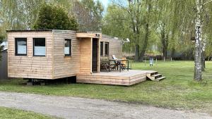 a small wooden cabin with a table in the grass at Gemütliches Mobilheim in Gager auf Mönchgut in Gager