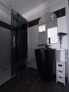 un bagno con doccia, lavandino e specchio di La Douce Parenthèse B&B entre bois et champs-Accueil motards a Montirat