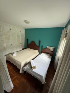 twee bedden in een kamer met blauwe muren bij Aconchegante casa com piscina e lazer completo in Teresópolis +85 foto's