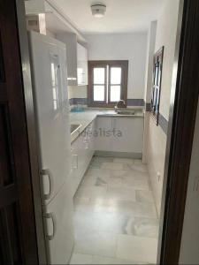 a kitchen with a hallway with a sink and a refrigerator at La Casita de Ventorros in Loja