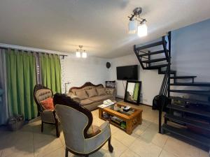 圣地亚哥Hostel Tu Espacio RE - Casa cerca del Aeropuerto的带沙发和桌子的客厅
