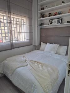 a white bed in a room with a window at Studio close to Descartes high school in Rabat