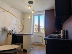 a kitchen with a counter and a table and a window at Calme sérénité et lumière in Grenoble +16 photos