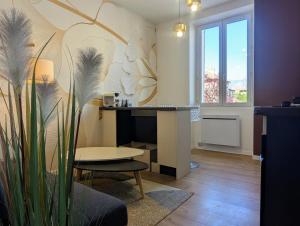 a living room with a desk and a table at Calme sérénité et lumière in Grenoble