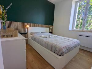 a bedroom with a bed and a green wall at Calme sérénité et lumière in Grenoble