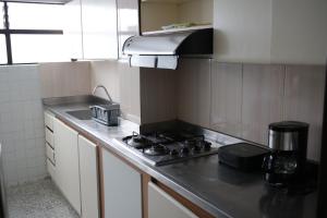 a small kitchen with a stove and a sink at Roomies House By Rincon in Medellín