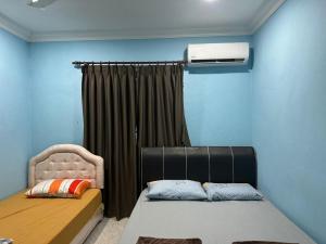 a bedroom with a bed and a air conditioner at Karen Homestay Likas in Kota Kinabalu