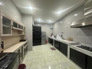 a large kitchen with a stove and a refrigerator at Karen Homestay Likas in Kota Kinabalu