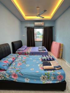 two beds in a room with blue walls at Karen Homestay Likas in Kota Kinabalu +5 photos