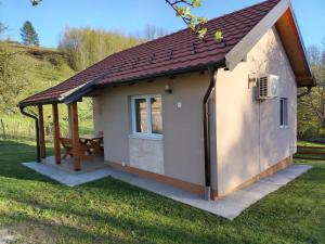 a smallshed with a picnic table in the grass at Vikendica Batin Konak in Bajina Bašta