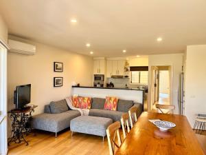 a living room with a couch and a table at Miranda Oasis in Torquay