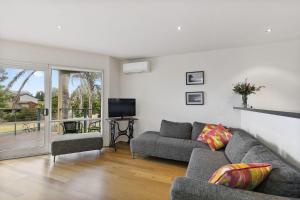 a living room with a couch and a television at Miranda Oasis in Torquay