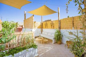 马拉喀什Riad JONCHÈRES的庭院配有白色沙发和遮阳伞。