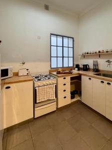 a kitchen with white cabinets and a stove top oven at Lo de Nina in Azul