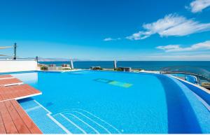 a swimming pool on top of a building with the ocean at Luxury Seaview Beachfront Apartment Pools,Jacuzzi,Gym in Arenales del Sol
