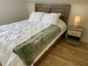 a bed with a green blanket on top of it at Chez Thomas, la maison du pêcheur in Grande Anse