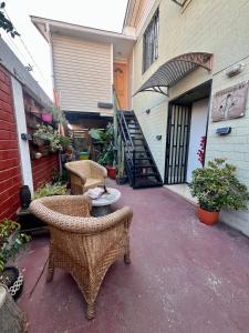 a patio with wicker chairs and a table in front of a building at Hostel Tu Espacio RE - Habitaciones cerca del Aeropuerto in Santiago +16 photos
