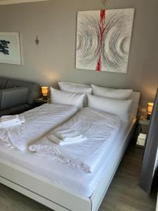 a bed with white sheets and pillows in a room at Deck 29 in Timmendorfer Strand