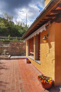 a building with a pot of flowers on a brick patio at Casa Magnolia in Bientina +21 photos