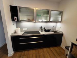 a kitchen with black cabinets and a sink at Apartamento Laredo con Terraza in Laredo