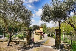 a gate in front of a house with trees at Casa Magnolia in Bientina +22 photos