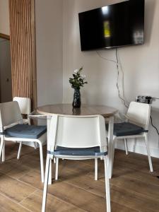 a dining room table with chairs and a tv on a wall at Apartamento Laredo con Terraza in Laredo