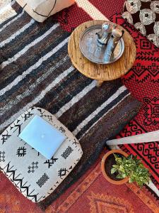 a table with a laptop on top of a rug at TAMOUNT Surf House in Agadir +54 photos
