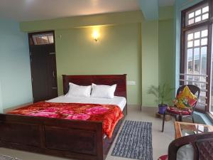 a bedroom with a bed with a red blanket at The Mountain Range Homestay in Darjeeling