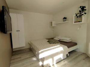 a small bedroom with a bed and a television at Courtyard Condo Twin in Liepāja