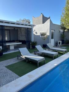 a swimming pool with lounge chairs next to a house at Dar Yaza in Al Ghar