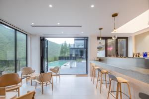 un ristorante con bar e vista sulla piscina di Moganshan Linqiguyin Hotel a Fanjiawu