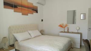 een slaapkamer met een bed en een schilderij aan de muur bij Vello Blu in Giovinazzo