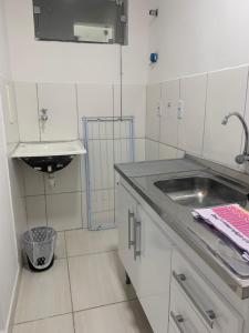 una cucina bianca con un lavello e un bancone di Kitnet Sonho de Verão a Santa Cruz Cabrália