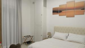 een witte slaapkamer met een bed en een stoel bij Vello Blu in Giovinazzo +99 foto's